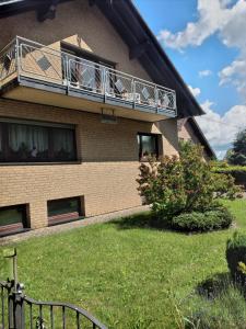 a house with a balcony with people on it at Ferienwohnung-Freuen in Blankenheim