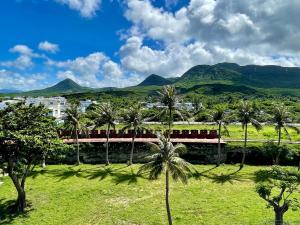 a train traveling past palm trees with mountains in the background at Mountains Inn in Hengchun South Gate
