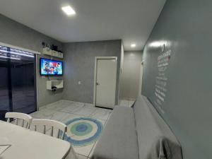 亞美利迦納的住宿－Bela Casa Piscina Aquecimento Solar em Americana-SP，一间设有桌椅和电视的等候室