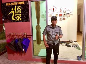 un joven parado frente a una tienda en HUAQIAO HOME 侨之家免费供早餐free breakfast served en Semporna