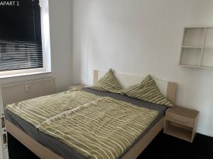 a bedroom with a bed with a striped comforter and a window at Apartment in Solingen Ohligs in Solingen