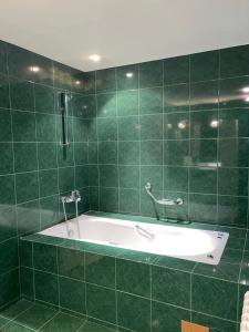 a green tiled bathroom with a bath tub at Villa Alexa in Borovets