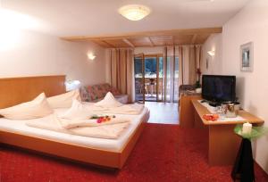 マルテッロにあるHotel Restaurant Waldheimのベッドとテレビが備わるホテルルームです。