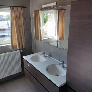 a bathroom with two sinks and a large mirror at Vakantiewoning Op Den Briel in Lokeren