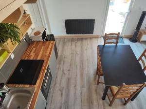 a kitchen with a table and a table and chairs at Petit Coin de Bonheur studio Neuf et lumineux à 5mins du Centre-ville in La Mure