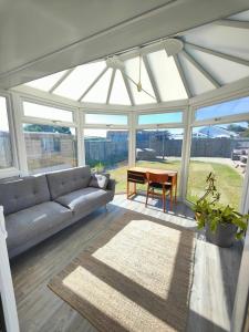 a living room with a couch and a table at Seaside bungalow 5 mins walk to beach and town in Bude