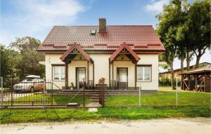 mały biały dom z czerwonym dachem w obiekcie Holiday Home Mielno Akacjowa Ii w mieście Mielno