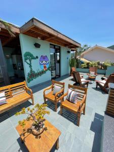 a patio with benches and a table and a painting at Hospedaria da Lagoa in Florianópolis