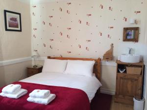 a bedroom with a bed with two towels on it at Rose and Crown B&B in Burwash
