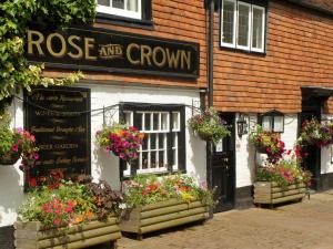 a store with flowers in the windows of a building at Rose and Crown B&B in Burwash +37 photos