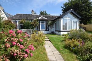 a house with a garden and some flowers at Ashburn Cottage in Lochgoilhead