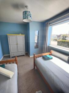 a bedroom with two beds and a window at Seaside bungalow 5 mins walk to beach and town in Bude