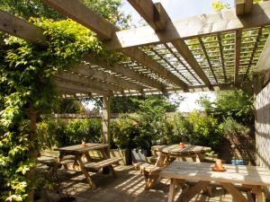 a picnic table under a wooden pergola at Rose and Crown in Burwash