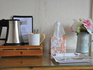 a table with a vase of flowers and a box of tissues at Rose and Crown in Burwash