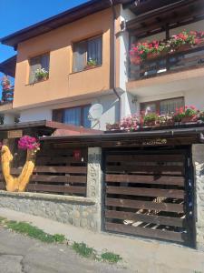 ein Gebäude mit Blumenkästen auf einer Holzgarage in der Unterkunft Guest House Markovi in Govedartsi