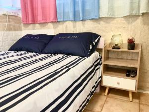 a bed with blue and white striped pillows and a shelf at Dotan's Boutique Apartments - By The Beach! in Tel Aviv