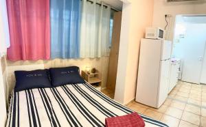 ein kleines Schlafzimmer mit einem Bett und einem Kühlschrank in der Unterkunft Dotan's Boutique Apartments - By The Beach! in Tel Aviv