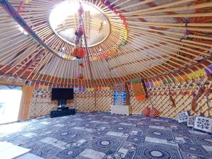 Karakol Yurt Village في كاراكول: غرفة كبيرة مع سقف كبير مع عجل