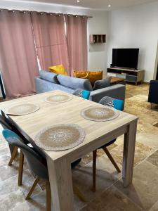 sala de estar con mesa y sofá en Magnifique maisonnette Dépendance avec Piscine en Châteaurenard