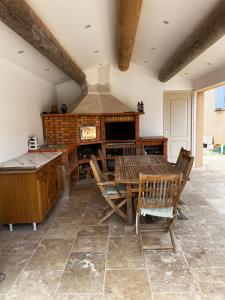 une salle à manger avec une table et une cheminée dans l'établissement Magnifique maisonnette Dépendance avec Piscine, à Châteaurenard