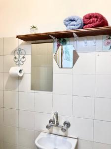 a bathroom with a sink and towels on a shelf at Dotan's Boutique Apartments - By The Beach! in Tel Aviv