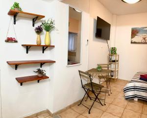 una camera con una parete bianca, scaffali e un tavolo di Dotan's Boutique Apartments - By The Beach! a Tel Aviv