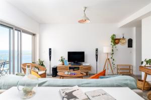 a living room with a couch and a tv at Sesimbra Sunshine Cliffs in Sesimbra