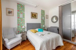 a bedroom with a bed and a chair at GuestReady - Vibrant & Cosy in Montparnasse in Paris