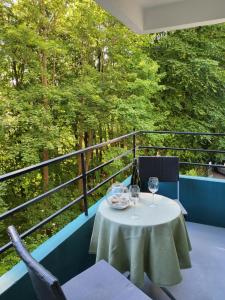 einen Tisch mit zwei Weingläsern auf dem Balkon in der Unterkunft Kurpark Appartement in Glücksburg
