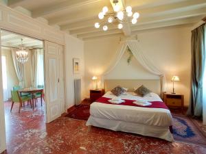 a bedroom with a bed with a chandelier and a table at Domaine de Rasigous in Saint-Affrique-les-Montagnes