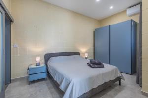 1 dormitorio con 1 cama y armario azul en Celestina Farmhouse, en Xagħra 23 fotos más