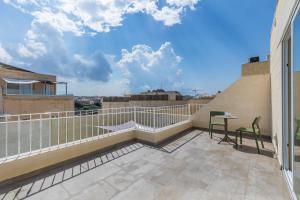 - Balcón con mesa y sillas en un edificio en Celestina Farmhouse, en Xagħra