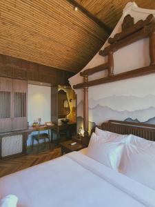 um quarto com uma cama grande e uma secretária com uma mesa em MINH - CASA em Hoi An