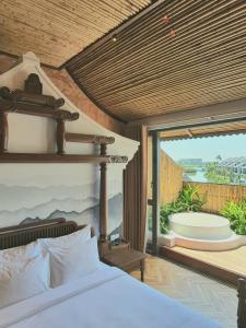 um quarto com uma cama e uma varanda com uma banheira em MINH - CASA em Hoi An