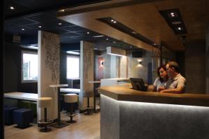 zwei Männer, die mit einem Laptop an einer Bar sitzen in der Unterkunft Ibis Budget Bilbao Barakaldo in Barakaldo