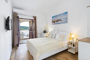 a white bedroom with a bed and a balcony at Black Pearl Tisno in Tisno +114 photos