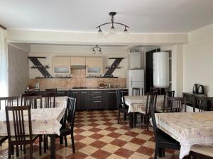 cocina y comedor con mesas y sillas en Pensiunea Aby, en Sovata