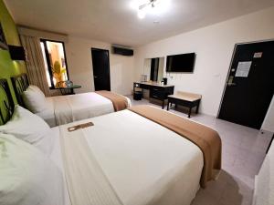 a hotel room with three beds and a desk at Maya Tulipanes Express in Palenque