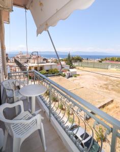 balcón con mesa, sillas y vistas al océano en Λεμονιά Ενοικιαζόμενα δωμάτια, en Loutra Edipsou