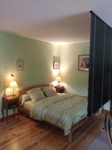 ein Schlafzimmer mit einem Bett und zwei Lampen an Tischen in der Unterkunft Studio 45m2, à la campagne, à 15 mns du Puy en Velay in Lantriac