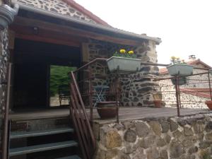 ein Steinhaus mit einer Holzterrasse und einer Treppe in der Unterkunft Studio 45m2, à la campagne, à 15 mns du Puy en Velay in Lantriac