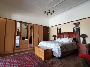 a bedroom with a bed and a dresser and mirror at Die Blom in Krugersdorp