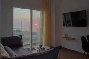 a living room with a couch and a large window at Stegna Sunny Beach- up floor in Archangelos