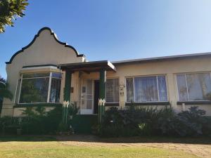 una casa con finiture verdi e bianche di Die Blom a Krugersdorp