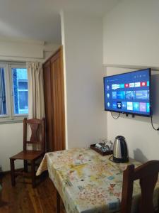 um quarto com uma mesa e uma televisão na parede em Astoria Patagonia habitaciones privadas em San Carlos de Bariloche