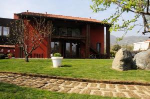 um edifício vermelho com uma grande rocha em frente em Mehdi's home em Pinerolo