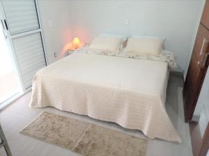 Casa de Campo Recanto Têto في إسبيريتو سانتو دو بينهال: غرفة نوم مع سرير مع لحاف أبيض
