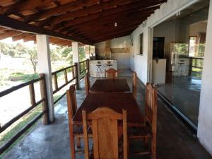 comedor con mesa y sillas en el porche en Casa de Campo Recanto Têto en Espirito Santo Do Pinhal