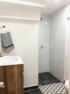 a white bathroom with a sink and a shower at Apartaestudio moderno y acogedor con PARKING in Sabaneta