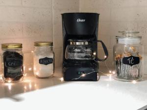 a kitchen counter with jars and a coffee maker at Apartaestudio moderno y acogedor con PARKING in Sabaneta